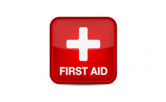 Red sign with a cross that says 'first aid''.