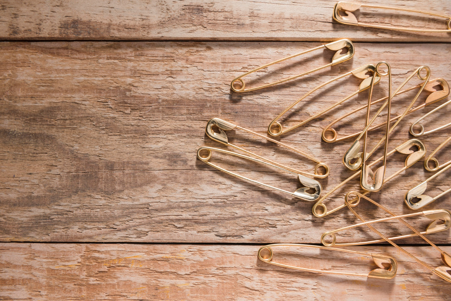 safety pins on wooden board