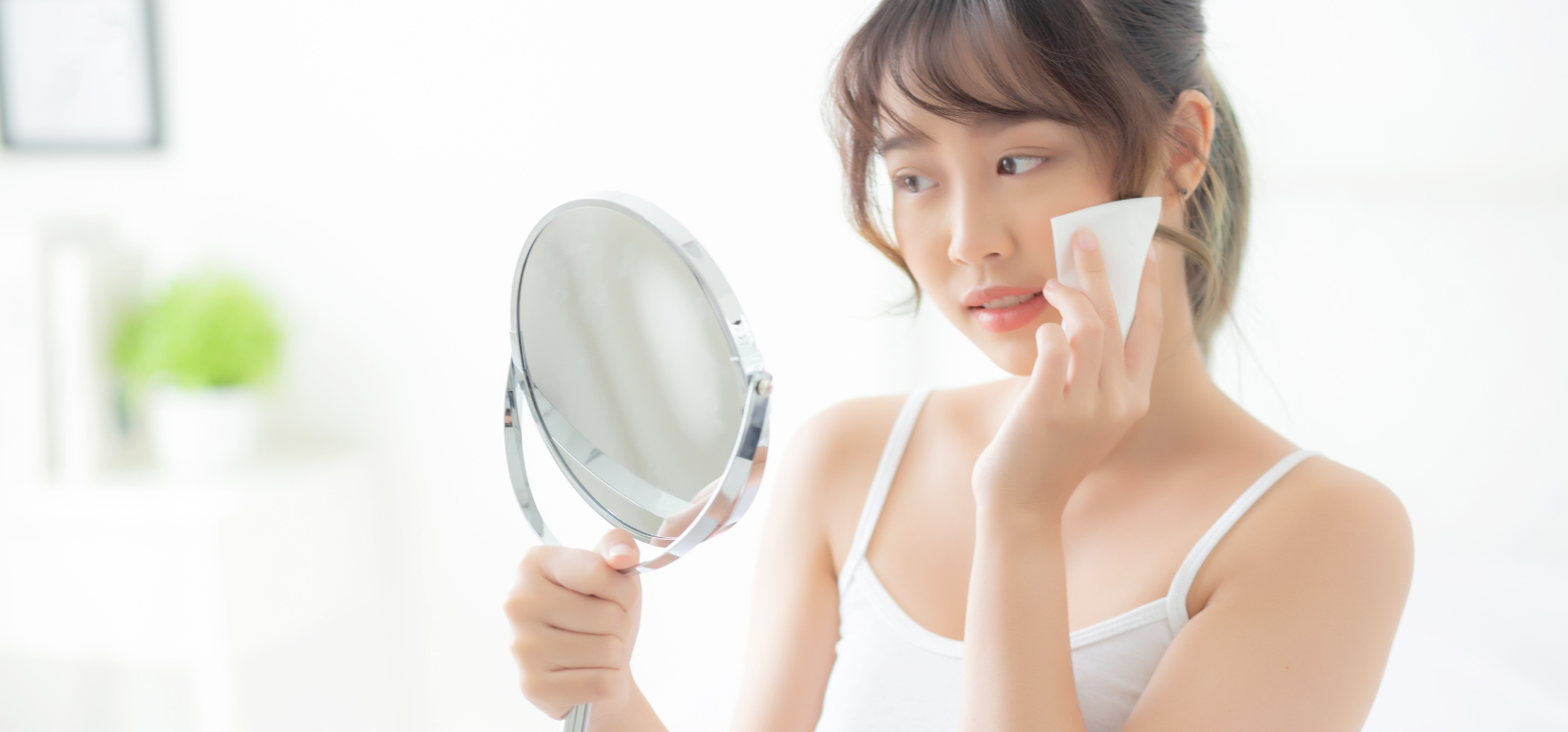 A women with facial Wipes and a mirror