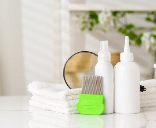 A professional head lice treatment kit including nit combs, removal lotion bottles, and clean white towels, arranged for an effective home treatment routine.