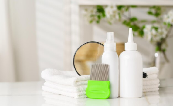 A professional head lice treatment kit including nit combs, removal lotion bottles, and clean white towels, arranged for an effective home treatment routine.