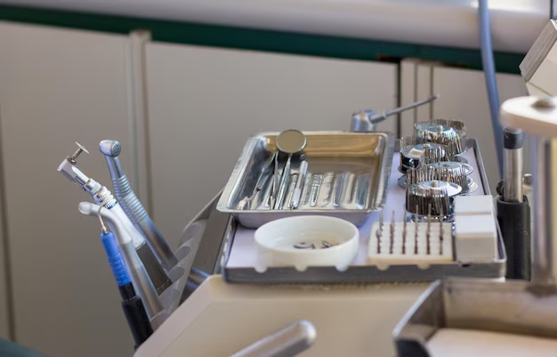 A professional array of high-quality dental laboratory supplies and clinical instruments, including burs and mirrors, set up in a sterile hospital or dental practice environment.