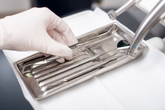 Close-up of professional dental supplies including mouth mirrors and probes on a medical tray, used for daily oral care and checkups.
