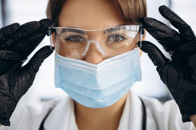 A healthcare professional wearing clear protective eyewear, a surgical mask, and black nitrile gloves, demonstrating the importance of comfortable personal protective equipment (PPE)
