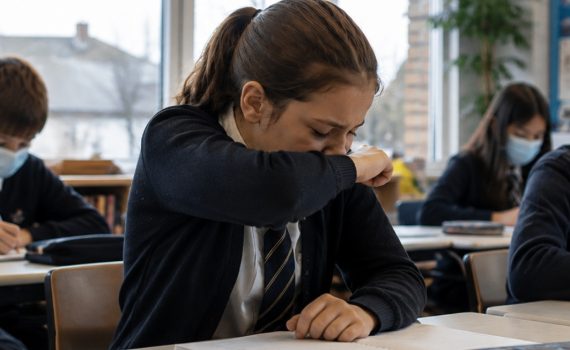 School students following respiratory hygiene practices in the classroom to help prevent the spread of illness.