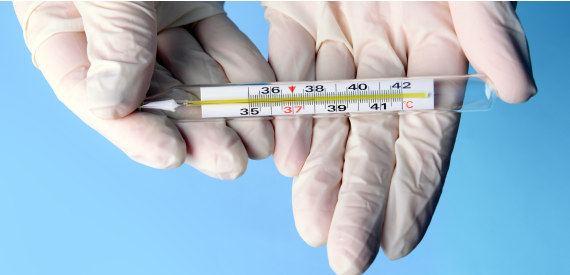 Laboratory technician holding a precision thermometer for temperature measurement, scientific research, quality control, and testing applications.