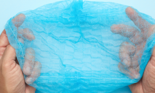 Blue disposable shower cap held open