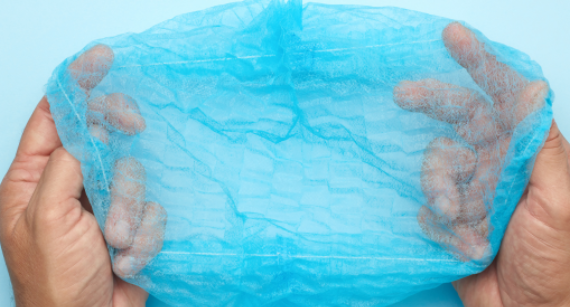 Blue disposable shower cap held open