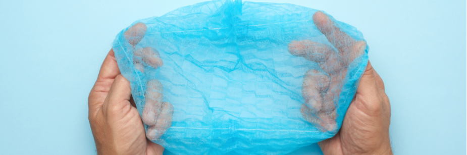 Blue disposable shower cap held open