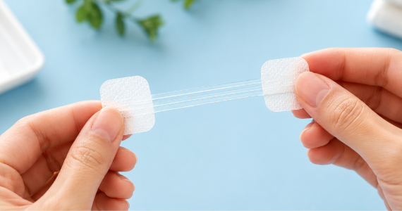 Hands holding butterfly wound closure strips