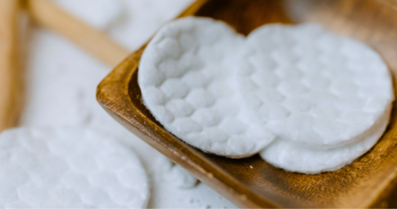Round cotton pads on wooden tray