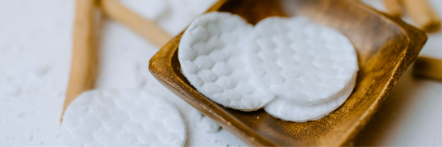 Round cotton pads on wooden tray