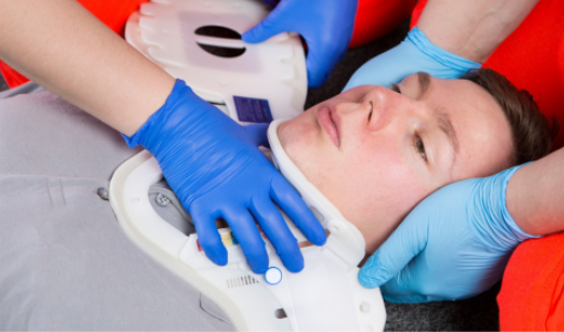 Emergency first aid demonstrating correct application of an extrication cervical collar for spinal protection.