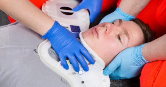 Emergency first aid demonstrating correct application of an extrication cervical collar for spinal protection.