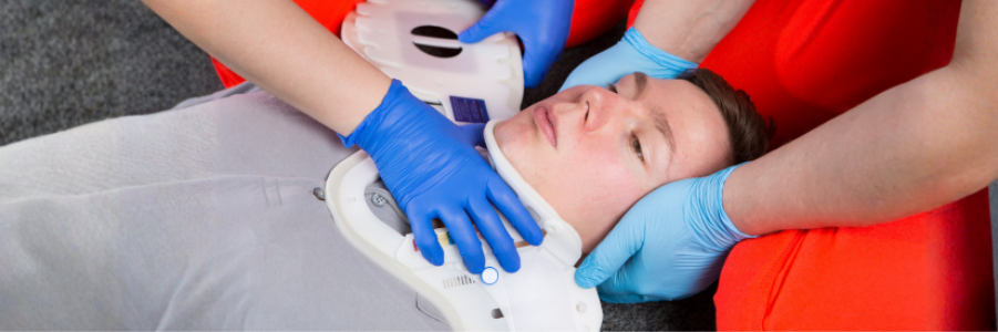 Emergency first aid demonstrating correct application of an extrication cervical collar for spinal protection.