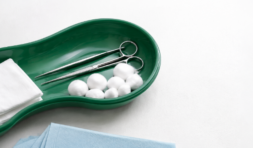 Kidney dish tray arranged with wound care supplies and medical instruments