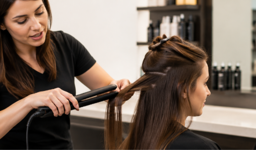 Professional hair straightener styling in salon.