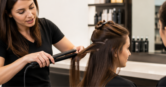 Professional hair straightener styling in salon.