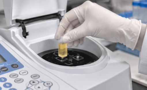 Laboratory technician placing a cuvette into a spectrophotometer for sample analysis