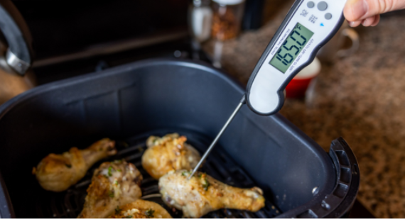 Food thermometer inserted into cooked chicken to check a safe internal temperature
