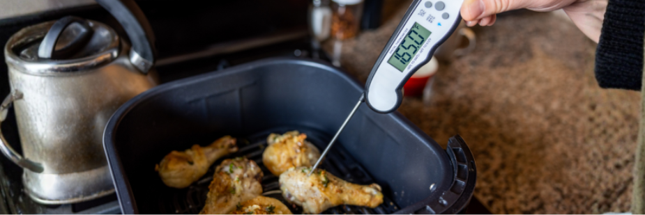 Food thermometer inserted into cooked chicken to check a safe internal temperature